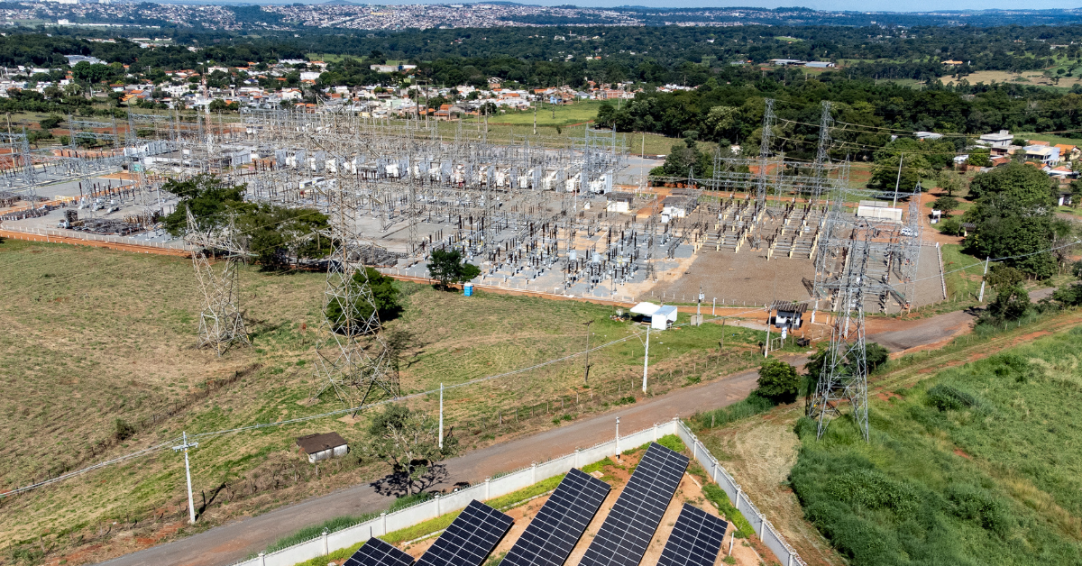 Aerial view of an electrical substation and solar array adjacent to undeveloped land parcels, demonstrating how power proximity creates value gradients for data center development.