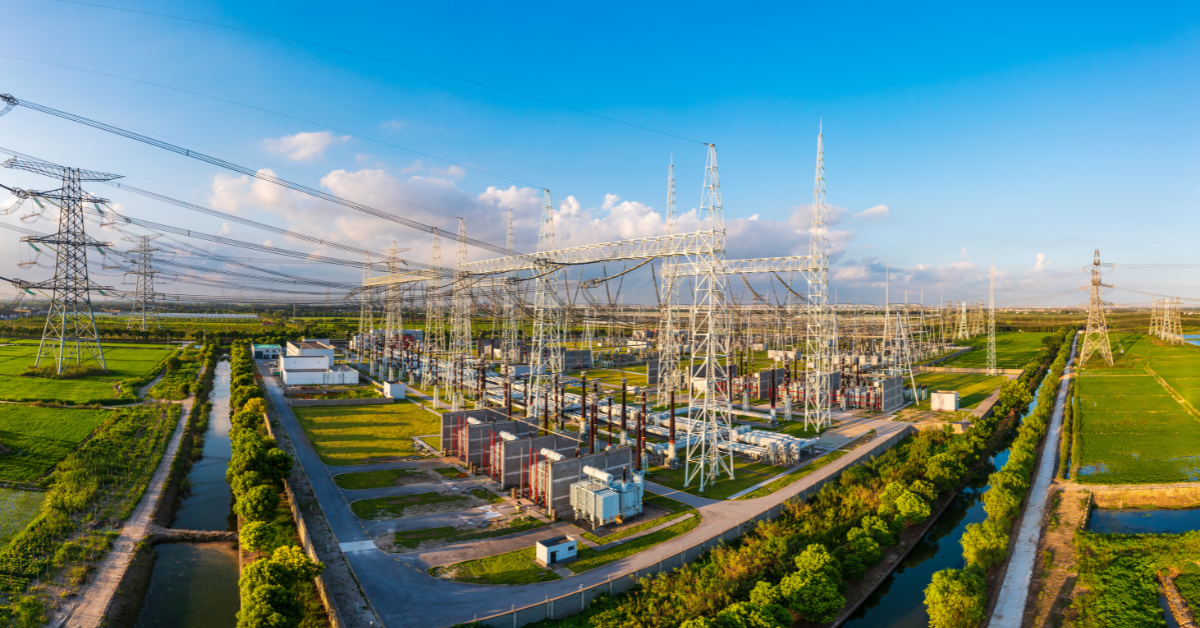 High-voltage electrical substation and power grid adjacent to rural land, demonstrating infrastructure proximity valuation analyzed on Acres