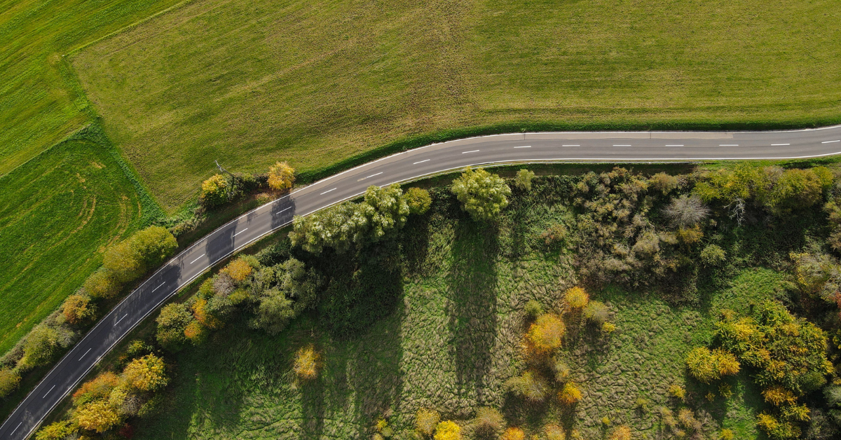 erial overhead satellite view of green farmland, timber acreage, and a paved access road representing property boundary and land evaluation mapping for DDK Forestry & Real Estate and Acres.