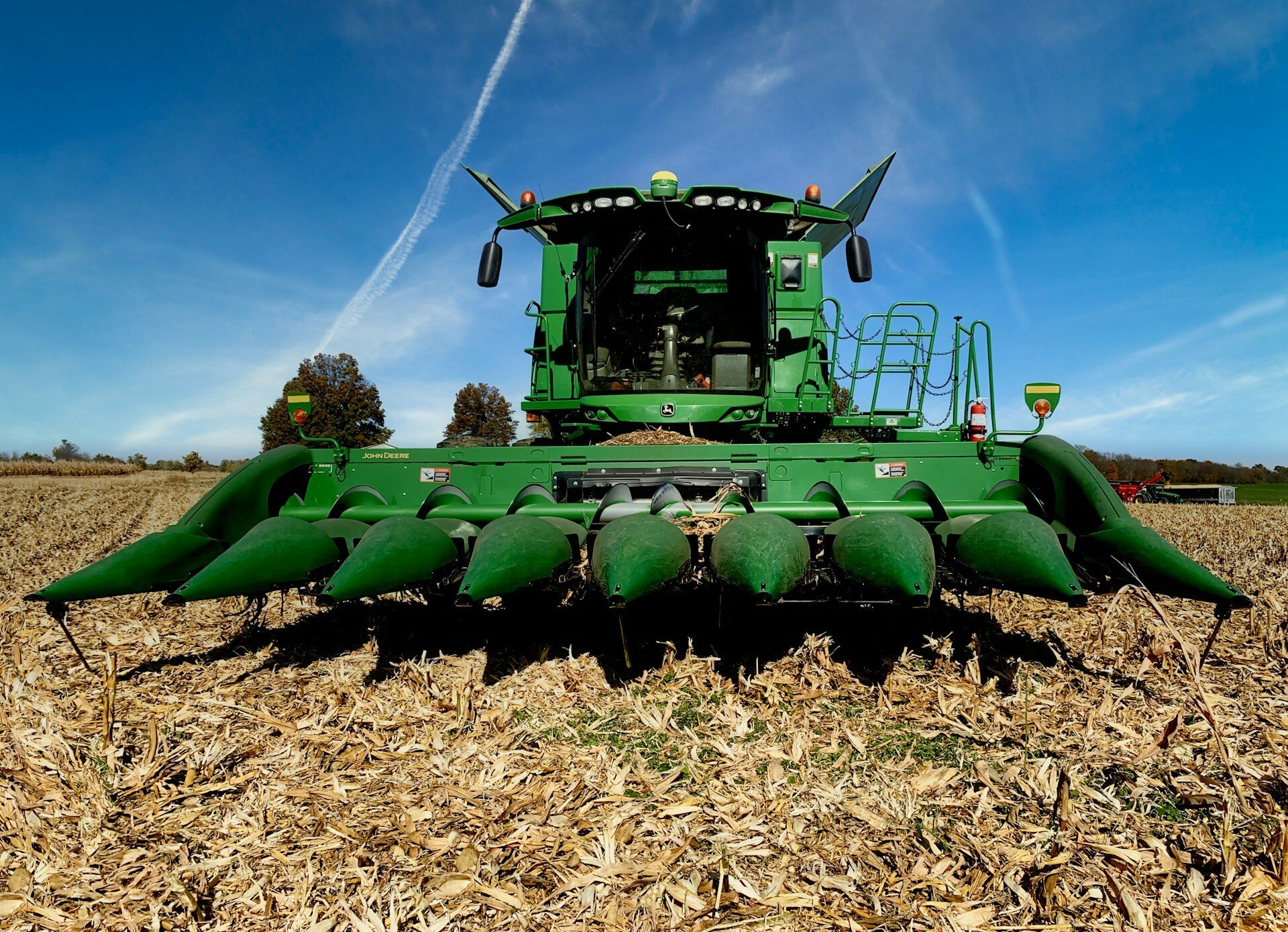 A green Combine Harvesting Machine in an Ohio cornfield.